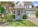 Inviting home with a covered porch, decorative wreath, and a well-kept lawn with lush plantings at 104 Wando Reach Rd, Wando, SC 29492