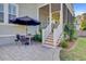 Covered patio with outdoor table and chairs leads to screened-in porch and a nicely landscaped yard at 104 Wando Reach Rd, Wando, SC 29492