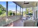 Screened porch with wood flooring and cozy seating area overlooking backyard at 104 Wando Reach Rd, Wando, SC 29492