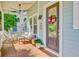 Relaxing covered porch with comfortable seating, potted plants, and a charming front door at 104 Wando Reach Rd, Wando, SC 29492