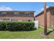 Backyard view of brick villas featuring white fencing, lush greenery, and a grass lawn at 111 Elmwood Ave # A, Ladson, SC 29456