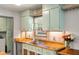 This charming kitchen features wood countertops, vintage-inspired cabinets, and stainless steel appliances at 1125 Oceanview Rd, Charleston, SC 29412