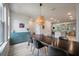 Open-concept dining room with long wooden table, light fixture, a built-in blue cabinet and view to the kitchen and living room at 114 Rowans Creek Dr, Charleston, SC 29492