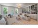 Bright living room with a built-in bookcase, cozy seating, and natural light from large windows at 114 Rowans Creek Dr, Charleston, SC 29492