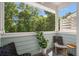 Inviting screened porch with two chairs, a small table, a potted plant, and serene view of the surrounding trees at 114 Rowans Creek Dr, Charleston, SC 29492