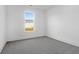 Clean, carpeted bedroom featuring a large window bringing in natural light with views of a house next door at 1215 Homecoming Blvd # Cc2-1-25, Ravenel, SC 29470