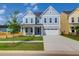 Charming two-story home with a well-manicured lawn, attached garage, and inviting blue door at 1215 Homecoming Blvd # Cc2-1-25, Ravenel, SC 29470