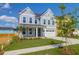 Charming two-story home with a well-manicured lawn, attached garage, and inviting blue door at 1215 Homecoming Blvd # Cc2-1-25, Ravenel, SC 29470