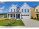 Charming two-story home with a well-manicured lawn, attached garage, and inviting blue door at 1215 Homecoming Blvd # Cc2-1-25, Ravenel, SC 29470