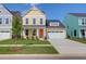 Inviting yellow two-story home with a manicured lawn, white garage door, and bright orange front door at 1217 Homecoming Blvd # Cc2-1-26, Ravenel, SC 29470