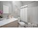 Modern bathroom with gray vanity, tub with shower, decorative art, and neutral color palette for a tranquil aesthetic at 1224 Midvale Ave, Charleston, SC 29412