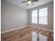 Bedroom with hardwood floors, two windows with curtains, light gray walls, a ceiling fan, and white baseboards at 1224 Midvale Ave, Charleston, SC 29412