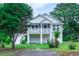 Charming coastal home featuring a covered porch, white siding, and well-maintained landscaping for inviting curb appeal at 1224 Midvale Ave, Charleston, SC 29412