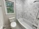 Modern bathroom features a white tiled shower-tub combo and a bright window view at 123 Lewisfield Dr, North Charleston, SC 29418