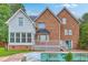 View of the backyard featuring a two-story brick and vinyl sided house with a neglected in-ground pool at 125 Eston Dr, Goose Creek, SC 29445
