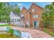 View of the back of a brick house, featuring a deck, a sunroom, and a neglected in-ground pool at 125 Eston Dr, Goose Creek, SC 29445