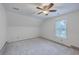 This bedroom is painted white and features a ceiling fan, a window, and carpeted floors at 125 Eston Dr, Goose Creek, SC 29445