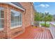 A red-stained wooden deck outside a brick home with a palm tree in the background at 125 Eston Dr, Goose Creek, SC 29445
