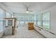 Sunroom with multiple windows, tile flooring, and a ceiling fan, filled with construction supplies at 125 Eston Dr, Goose Creek, SC 29445