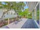Relaxing back deck with a gas grill, lush green trees, and a white painted house in the background at 13 32Nd Ave, Isle of Palms, SC 29451