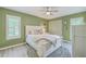 Cozy bedroom with a white wooden bed frame, ceiling fan and a light green painted wall at 13 32Nd Ave, Isle of Palms, SC 29451