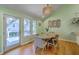 Bright dining area featuring a round wooden table, modern lighting, and a door leading to an outdoor patio at 13 32Nd Ave, Isle of Palms, SC 29451