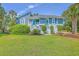 Charming two-story home with a bright turquoise door and beautifully landscaped front yard at 13 32Nd Ave, Isle of Palms, SC 29451