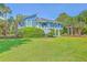 Charming two-story home with blue siding, a manicured lawn, and tropical palm trees at 13 32Nd Ave, Isle of Palms, SC 29451