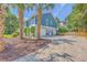 Exterior elevation of a house with a white garage door, palm trees, and a blue facade at 13 32Nd Ave, Isle of Palms, SC 29451