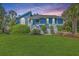 Inviting home with blue siding, complemented by a lush green lawn and manicured shrubbery at 13 32Nd Ave, Isle of Palms, SC 29451