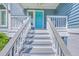 Close up of the home's front porch with a teal door and well-kept gray stairs at 13 32Nd Ave, Isle of Palms, SC 29451