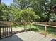 Backyard with wood deck, bordered by a wood fence and mature trees at 1317 Wild Olive Dr, Mount Pleasant, SC 29464