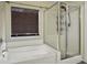 Bright bathroom featuring a soaking tub next to a glass enclosed shower with shelving at 1317 Wild Olive Dr, Mount Pleasant, SC 29464