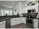 Well-lit kitchen featuring stainless steel appliances, white cabinets, and dark countertops at 1317 Wild Olive Dr, Mount Pleasant, SC 29464