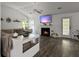 Inviting living room with a fireplace, hardwood floors, a ceiling fan, a sectional couch, and plants at 1317 Wild Olive Dr, Mount Pleasant, SC 29464