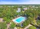 Aerial view of community pool by the lake surrounded by mature trees and sun loungers at 1317 Wild Olive Dr, Mount Pleasant, SC 29464