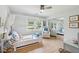 Well-lit bedroom featuring light-wood floors, a white canopy bed, and a comfortable armchair near a window at 1467 Battalion Dr, James Island, SC 29412