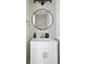 Neat half bathroom features a sink with vanity, round mirror, and good lighting at 15 H Street St, Charleston, SC 29403