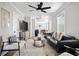 Open-concept living room featuring a leather sofa, hardwood floors, and a ceiling fan at 15 H Street St, Charleston, SC 29403