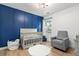 Bedroom featuring a blue accent wall, grey chair, and white crib at 1525 Cypress Pointe Dr, Mount Pleasant, SC 29466