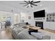 Bright living room featuring a fireplace, large sectional sofa, and modern ceiling fan at 1525 Cypress Pointe Dr, Mount Pleasant, SC 29466