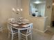 The dining area with white chairs, a chandelier and breakfast bar into the kitchen create a warm and inviting space at 1600 Long Grove Dr # 411, Mount Pleasant, SC 29464