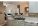 Open kitchen featuring a double sink, white cabinets and countertops and open views to the living area at 1600 Long Grove Dr # 411, Mount Pleasant, SC 29464