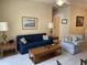 The well-lit living room showcases a classic blue sofa and a cozy checkered armchair, creating a comfortable ambiance at 1600 Long Grove Dr # 411, Mount Pleasant, SC 29464