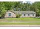 Charming single-story brick home featuring blue shutters and mature trees surrounding the landscaped front yard at 1673 Sulgrave Rd, Charleston, SC 29414