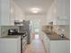 Galley kitchen featuring stainless steel appliances, granite countertops, mosaic tile backsplash, and white cabinetry at 1673 Sulgrave Rd, Charleston, SC 29414