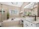 Bathroom featuring a large soaking tub, glass enclosed shower, and double granite sink at 1709 Blalock St, Mount Pleasant, SC 29466