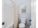 Bright bathroom features a tub shower combo with vinyl surround and a toilet adjacent to a window at 1709 Blalock St, Mount Pleasant, SC 29466