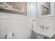 Elegant half bath with white pedestal sink, beadboard walls, and decorative map art creating a chic look at 1709 Blalock St, Mount Pleasant, SC 29466