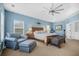 Spacious main bedroom featuring a tray ceiling and an upholstered chair and ottoman at 1709 Blalock St, Mount Pleasant, SC 29466
